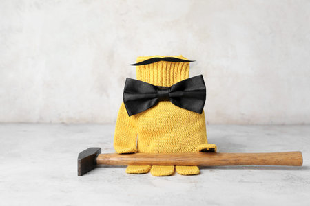 Glove with paper mustache, bow and hammer on grunge background. father's day celebrationの写真素材