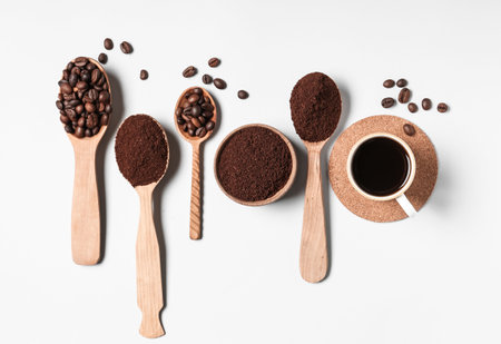 Spoons of coffee powder, beans and cup on white backgroundの写真素材