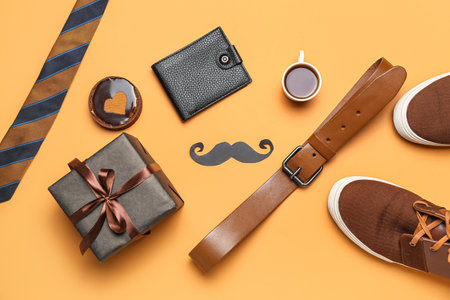 Composition with stylish male accessories, cup of coffee, cake and gift for Father's Day celebration on color backgroundの写真素材