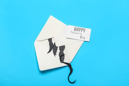 Envelope, paper mustaches and card with text HAPPY FATHER'S DAY on color background