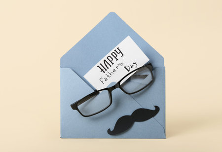 Composition with envelope, card, eyeglasses and paper mustache on color background. father's day...