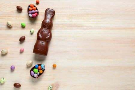 Chocolate Easter bunny with eggs on light wooden background