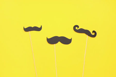 Set of paper mustaches on yellow backgroundの写真素材