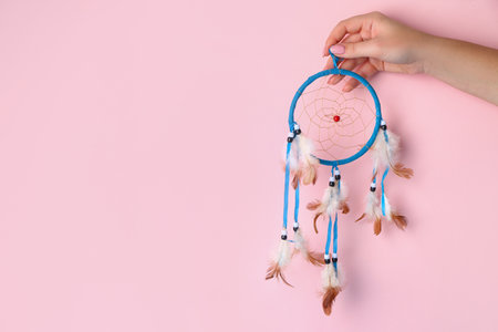 Woman with beautiful dreamcatcher on pink backgroundの写真素材