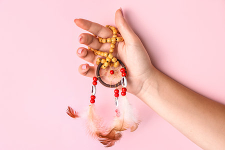 Woman with beautiful dreamcatcher on pink backgroundの写真素材