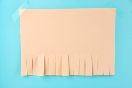 Blank paper tear-off ad on blue backgroundの写真素材