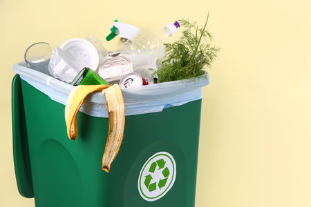 Recycle bin with garbage on yellow background, closeupの写真素材
