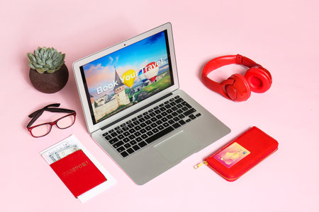 Modern laptop and travel accessories on color background. Concept of online bookingの写真素材