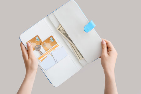 Female hands with travel organizer on gray background