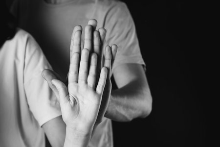 Hands of family on dark backgroundの写真素材