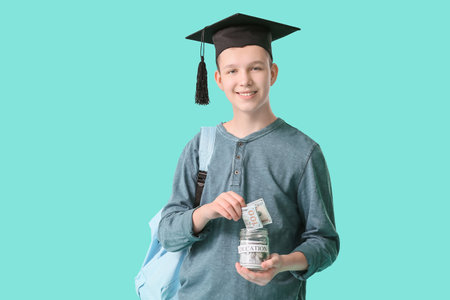 Teenage boy with savings for education on color backgroundの写真素材
