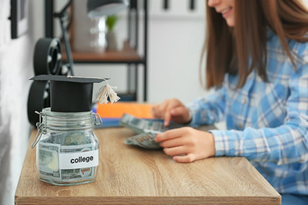 Teenage girl with savings for education and calculator at homeの写真素材