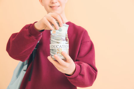 Teenage boy with savings for education on color background, closeupの写真素材