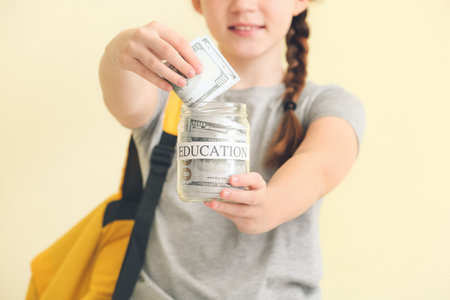 Girl with savings for education on color background, closeupの写真素材