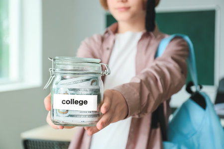 Teenage boy with savings for education in classroom, closeupの写真素材