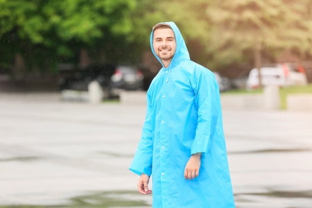 Young man wearing raincoat outdoorsの写真素材
