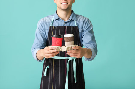 Young male barista on color backgroundの写真素材