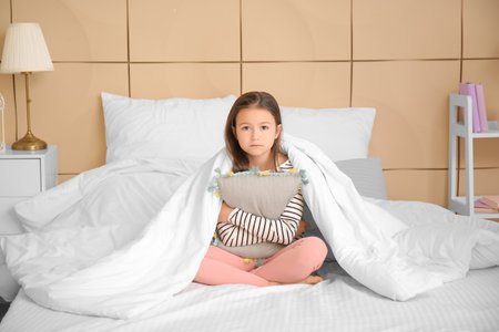 Little girl suffering from sleep disorder in the bedroomの写真素材