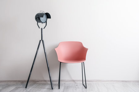 Stylish armchair with lamp near light wallの写真素材