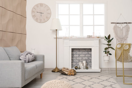 Stylish fireplace with sofa in interior of living roomの写真素材