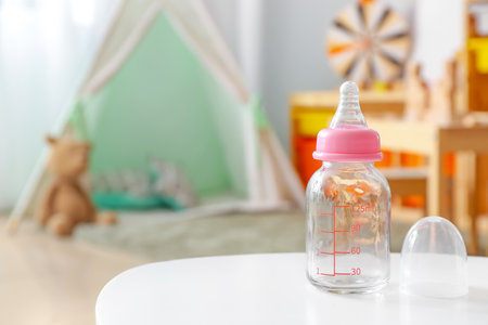 Baby bottle on table in roomの写真素材