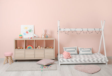 Interior of modern children's room with comfortable bed and rack with toysの写真素材