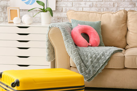 Travel pillow and suitcase in roomの写真素材