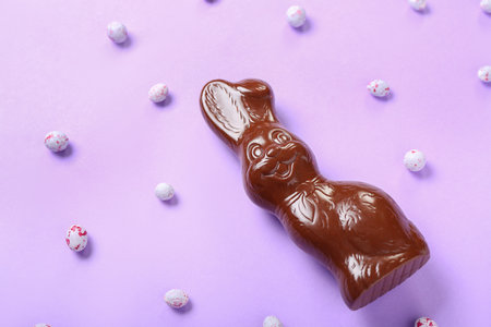 Chocolate Easter bunny with eggs on lilac backgroundの写真素材