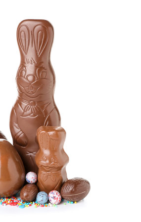 Chocolate Easter bunnies with eggs and sprinkles on white backgroundの写真素材