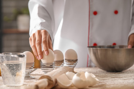 Female chef making dough for pasta at table in kitchen, closeupの写真素材