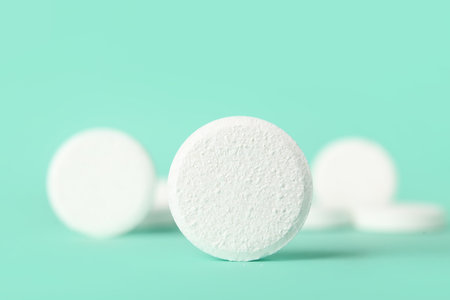 White soluble tablets on turquoise backgroundの写真素材