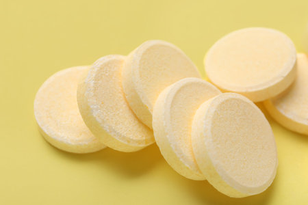 Soluble tablets on yellow backgroundの写真素材