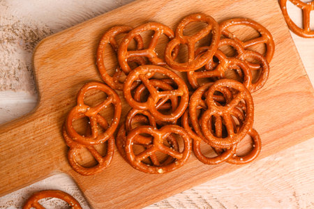 Board with tasty pretzels on light wooden background, closeupの写真素材