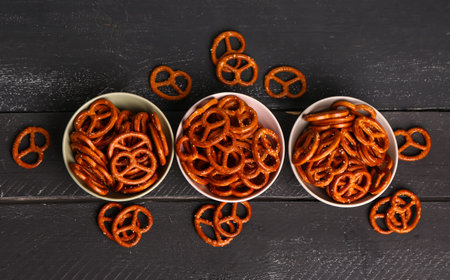 Bowls with tasty pretzels on dark color backgroundの写真素材
