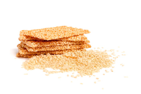 Stack of tasty kozinaki and sesame seeds on white backgroundの写真素材