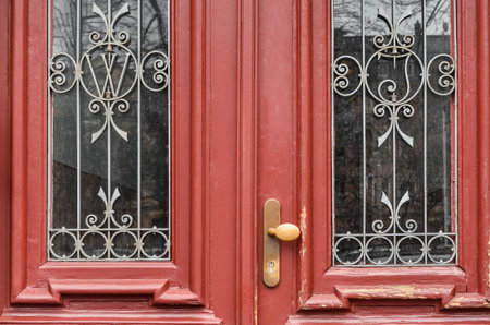View of old red door with windows in city, closeup