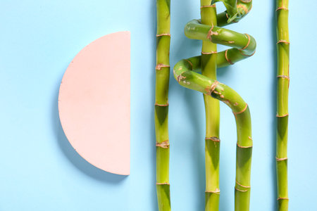 Green bamboo stems and plaster podium on turquoise backgroundの写真素材