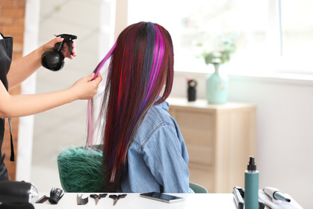 Hairdresser working with young woman in beauty salonの写真素材