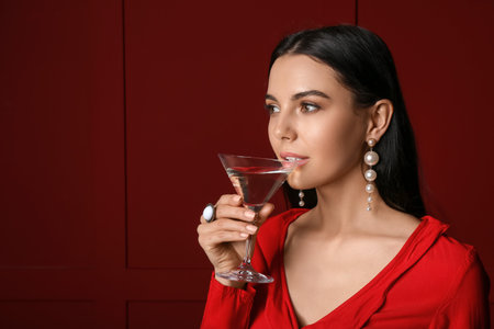 Beautiful young woman with martini on dark backgroundの写真素材