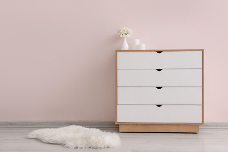 Modern chest of drawers with decor near color wall in roomの写真素材