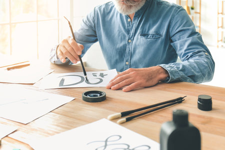 Senior male calligrapher working in officeの写真素材