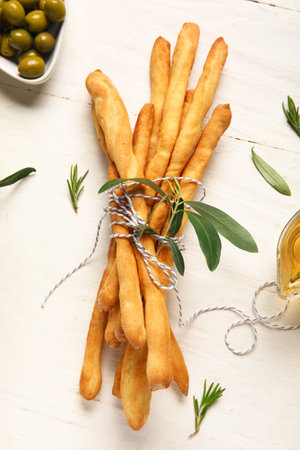 Bunch of tasty Italian Grissini on light wooden background
