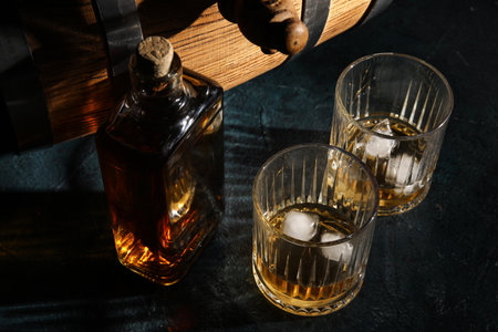 Glasses and bottle of cold whiskey on dark backgroundの写真素材