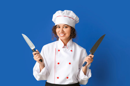 Female African-American chef with knives on color backgroundの写真素材