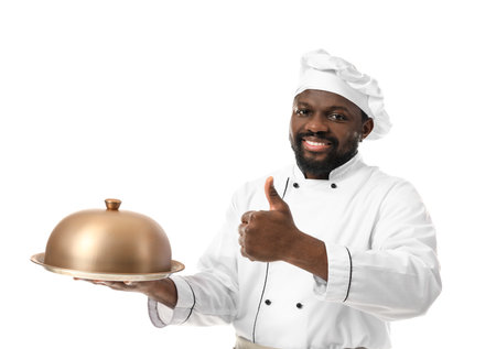 Male African-American chef with tray and cloche on white backgroundの写真素材