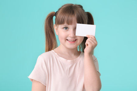 Little girl with business card on color backgroundの写真素材