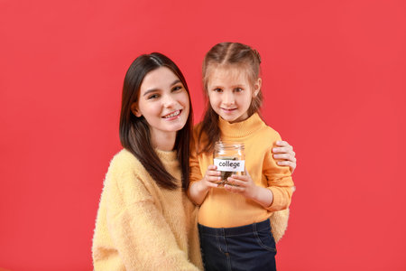 Little girl and her mother with savings for education on color background