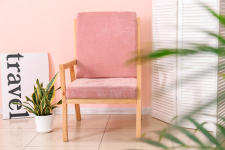 Stylish armchair near color wall in roomの写真素材