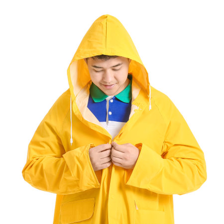 Young Asian man in raincoat on white backgroundの写真素材