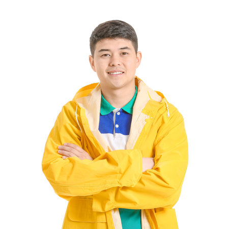 Young Asian man in raincoat on white backgroundの写真素材